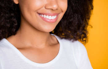 Wavy-haired girl over yellow background.