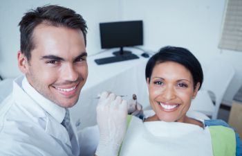 a dentist and a woman patient in a dental chair