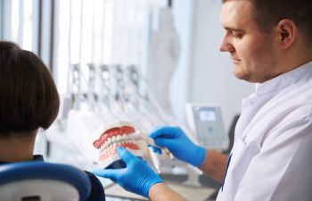 dentist educating a patient on dental hygiene