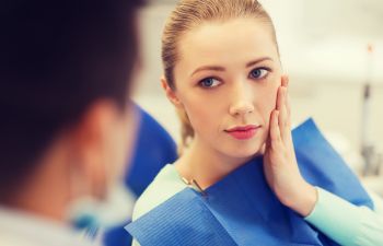 woman with dental pain in a dental chair at Smiles by Seese in Davidson NC