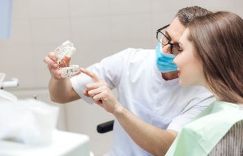 dentist showing dentures to a female patient