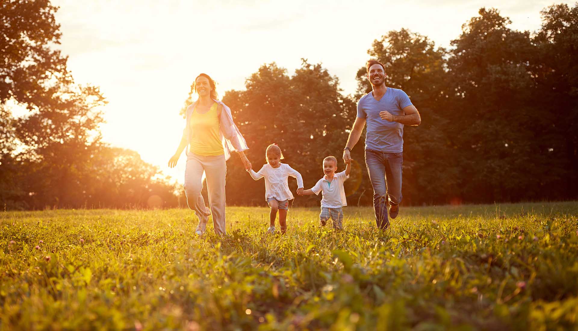 happy parents playing with their little girl and boy in a park