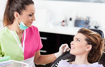 Woman dentist talking to her patient.