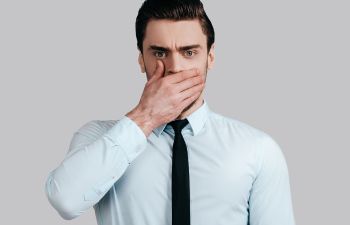 Man covering his mouth with his hand due to bad breath