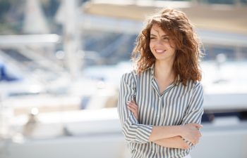 portrait of beautiful young smiling woman near the boats and yachts. Outdoors, lifestyle. Beautiful woman near the boats and yachts. Outdoors, lifestyle. sea or ocean background.